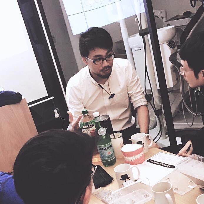 美學牙科專家黃醫師於診所內教授年輕牙醫師，分享陶瓷貼片與牙齦美學案例，提升微創治療與數位微笑設計的臨床技術。
